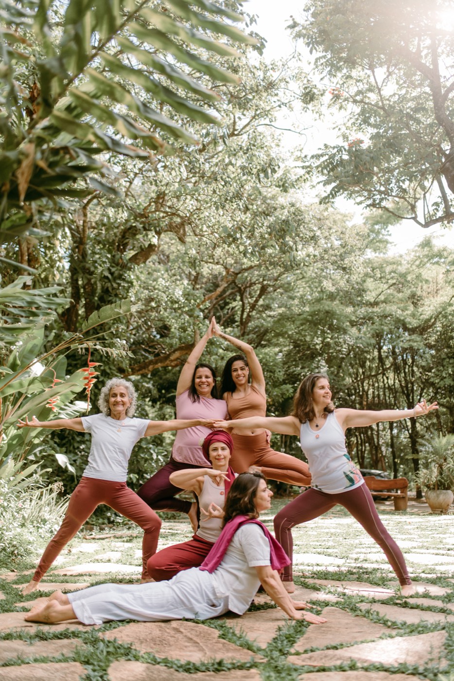 Grupo de yoga em pose de guerreiro ao ar livre